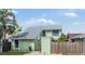 Charming two-story home with light green exterior, well-maintained landscaping, and a gray roof at 10306 Green Grove Pl, Tampa, FL 33624