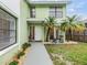 Inviting home entrance with a walkway, a small lawn, and chairs to enjoy the outdoors at 10306 Green Grove Pl, Tampa, FL 33624