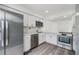 Modern kitchen features stainless steel appliances, white cabinets and wood-look flooring at 10306 Green Grove Pl, Tampa, FL 33624