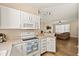 Open concept kitchen featuring white cabinets and stainless appliances with a living area view at 11047 Black Swan Ct, Seffner, FL 33584