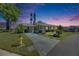 Charming home exterior at twilight with landscaped front yard, complemented by a unique driveway design at 119 Glendower Cir # 269, Sun City Center, FL 33573