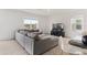 A spacious living room featuring a large sectional sofa and a wall-mounted TV at 16051 Weathered Windmill Ter, Odessa, FL 33556