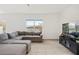 Comfortable living room with modern furniture, tiled floors, and a lake view from the window at 16051 Weathered Windmill Ter, Odessa, FL 33556