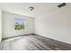 Bedroom with gray wood-look floors and natural light from a window at 16170 Traditional Bluff Pl, Odessa, FL 33556