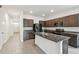 Well-lit kitchen with granite countertops, stainless steel refrigerator, and a central island at 16170 Traditional Bluff Pl, Odessa, FL 33556