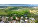 Aerial view of the property near a pond and a bay, surrounded by lush greenery and residential areas at 1754 Patricia Ave, Dunedin, FL 34698
