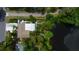 Overhead view shows the house, patio, and lake surrounded by lush greenery and a pergola at 1754 Patricia Ave, Dunedin, FL 34698