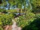 Lush backyard landscaping and walkway lead to tranquil water views in this charming waterfront home at 1754 Patricia Ave, Dunedin, FL 34698