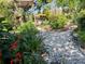 Backyard landscape featuring a stone path winding through a garden with pergola and plants at 1754 Patricia Ave, Dunedin, FL 34698