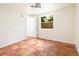 Empty bedroom features terracotta floors, white walls, and a view of the backyard through a large window at 1754 Patricia Ave, Dunedin, FL 34698