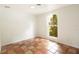 Bright room featuring unique terracotta tile flooring and a window offering a lush outdoor view at 1754 Patricia Ave, Dunedin, FL 34698