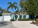 Charming home with a well-manicured front yard featuring tropical plants, flowers, and a concrete driveway at 1754 Patricia Ave, Dunedin, FL 34698
