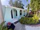 Covered front porch with decorative arched entryways and a garden featuring tropical plants at 1754 Patricia Ave, Dunedin, FL 34698