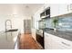 Updated kitchen with stainless steel appliances, a stylish tile backsplash, and a spacious island at 1754 Patricia Ave, Dunedin, FL 34698