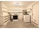 Functional laundry room with washer, dryer, shelving, and ample storage space at 1754 Patricia Ave, Dunedin, FL 34698