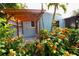 Outdoor shower featuring a privacy screen and surrounded by beautiful tropical landscaping at 1754 Patricia Ave, Dunedin, FL 34698