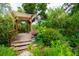 Wooden pergola in a lush garden with vibrant greenery, offering a tranquil outdoor retreat at 1754 Patricia Ave, Dunedin, FL 34698
