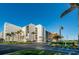 Exterior shot of the condo building with a circular drive and lush palm trees at 19111 Vista Bay Dr # 402, Indian Shores, FL 33785