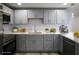 Updated kitchen features stainless steel appliances, gray cabinetry, and bright countertops at 19455 Fort Dade Ave, Brooksville, FL 34601