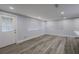 Living room with gray luxury vinyl plank flooring, white walls, and white trim at 19455 Fort Dade Ave, Brooksville, FL 34601
