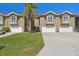 Well-maintained townhome exteriors offer attached garages, small balconies, and vibrant green lawns at 21205 Calle Rosa Dr # 10, Land O Lakes, FL 34637