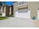 This townhome features a pristine garage door, a small balcony, and colorful potted plants at 21205 Calle Rosa Dr # 10, Land O Lakes, FL 34637