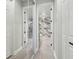 Hallway view of bathroom with glass shower door and marble-accented wall at 21205 Calle Rosa Dr # 10, Land O Lakes, FL 34637