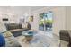 Open-concept living area with modern furniture, neutral walls, and sliders to the screened lanai and water view at 21205 Calle Rosa Dr # 10, Land O Lakes, FL 34637