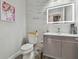 Stylish powder room with illuminated mirror, marble accent wall, and modern vanity at 21205 Calle Rosa Dr # 10, Land O Lakes, FL 34637