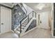 Modern staircase features ambient lighting, with gray accent wall and wood-look flooring in the home's entryway at 21205 Calle Rosa Dr # 10, Land O Lakes, FL 34637