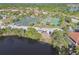 Aerial view of tennis courts and lush landscape, close to the lake and local buildings at 21205 Calle Rosa Dr # 10, Land O Lakes, FL 34637