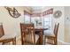 Cozy dining area with wood table, chairs, and natural light from the surrounding windows at 2514 Sandy Hill Ct, Holiday, FL 34691
