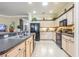 Kitchen features black appliances, light wood cabinets, and a neutral countertop at 2514 Sandy Hill Ct, Holiday, FL 34691