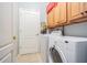 Laundry room with tile flooring, washer, dryer, and overhead cabinets at 2514 Sandy Hill Ct, Holiday, FL 34691