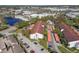 Aerial view of a condo complex with mature landscaping, parking and lake access to nearby retail shops at 2595 Countryside Blvd # 8-305, Clearwater, FL 33761