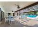 View of a community pool with tables, chairs and ceiling fans in shaded area for relaxing and enjoying the outdoors at 2595 Countryside Blvd # 8-305, Clearwater, FL 33761