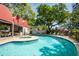 Resort-style pool with mature trees, an open-air kitchen, and plenty of lounge seating at 3211 W Swann Ave # 602, Tampa, FL 33609