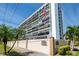 The Penland Condominium exterior showcasing a multi-story building with an American flag and lush landscaping at 3211 W Swann Ave # 602, Tampa, FL 33609