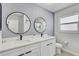 Bathroom featuring double sinks, modern fixtures, round mirrors, and stylish vanity for a contemporary appeal at 3214 40Th W St, Bradenton, FL 34205