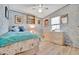 Cozy bedroom features light wood floors, a ceiling fan, and a comfortable bed with bright accents at 328 S Port Royal Ln, Apollo Beach, FL 33572
