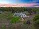 Aerial view of a home with large lot, a gazebo, and mature trees at sunset at 39745 River Rd, Dade City, FL 33525