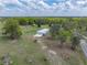 Sprawling acreage featuring a charming home, surrounded by lush trees, greenery, and a nearby road at 39745 River Rd, Dade City, FL 33525
