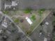 Aerial view of a charming home on a large triangular lot, with open space, a garden, and outbuildings at 39745 River Rd, Dade City, FL 33525