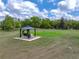 Picturesque backyard featuring a gazebo with a swing, set in a tranquil, grassy landscape at 39745 River Rd, Dade City, FL 33525