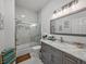 Bathroom with a gray vanity, a marble countertop, a large mirror, and a tub/shower combo at 39745 River Rd, Dade City, FL 33525