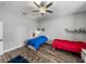 Bright bedroom with two twin beds, wood floors, and a modern ceiling fan at 39745 River Rd, Dade City, FL 33525