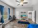 Bedroom featuring wood floors, a window with blue curtains, and two gaming chairs at 39745 River Rd, Dade City, FL 33525