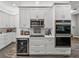 Gourmet kitchen with sleek white cabinets, stainless steel appliances, and a beverage cooler for entertaining at 39745 River Rd, Dade City, FL 33525