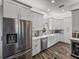 Updated kitchen boasts stainless steel appliances, white cabinetry, and a convenient beverage cooler at 39745 River Rd, Dade City, FL 33525