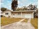 Single-story home with a driveway, attached garage, and neutral exterior paint at 4033 Newcastle Dr, New Port Richey, FL 34652